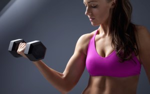 Studio photo of attractive young woman lifting dumbbell.; Shutterstock ID 96921779; PO: aol; Job: production; Client: drone